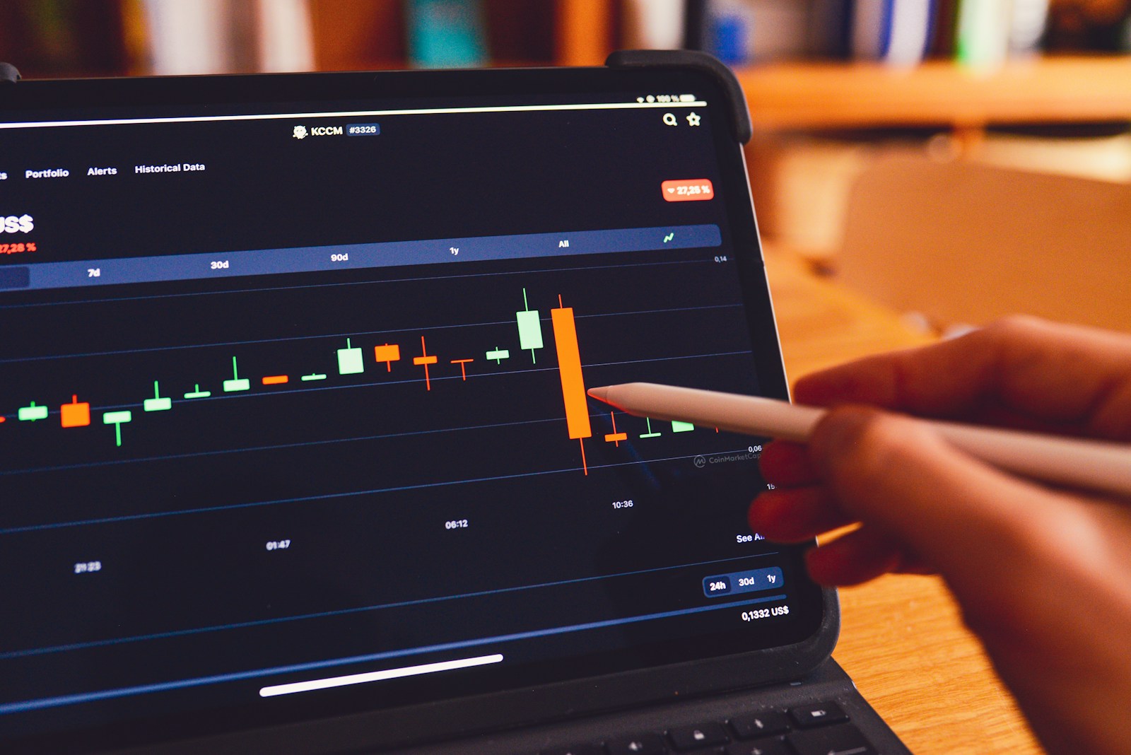 Person at a laptop showing a stock chart on screen