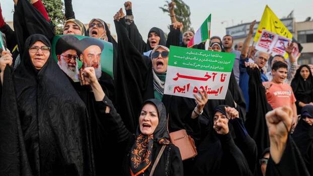 Iranische Demonstranten in Teheran halten Plakate hoch — Mai 2026, Iran-Krieg-Kosten erreichen 1 Billion Dollar Schätzung